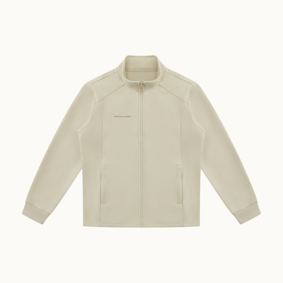North & Rowe beige unisex full zip performance track jacket with a stand collar and side pockets.