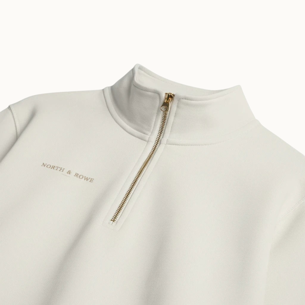 North & Rowe cream organic cotton quarter zip pullover with a metallic zipper and minimalist chest logo